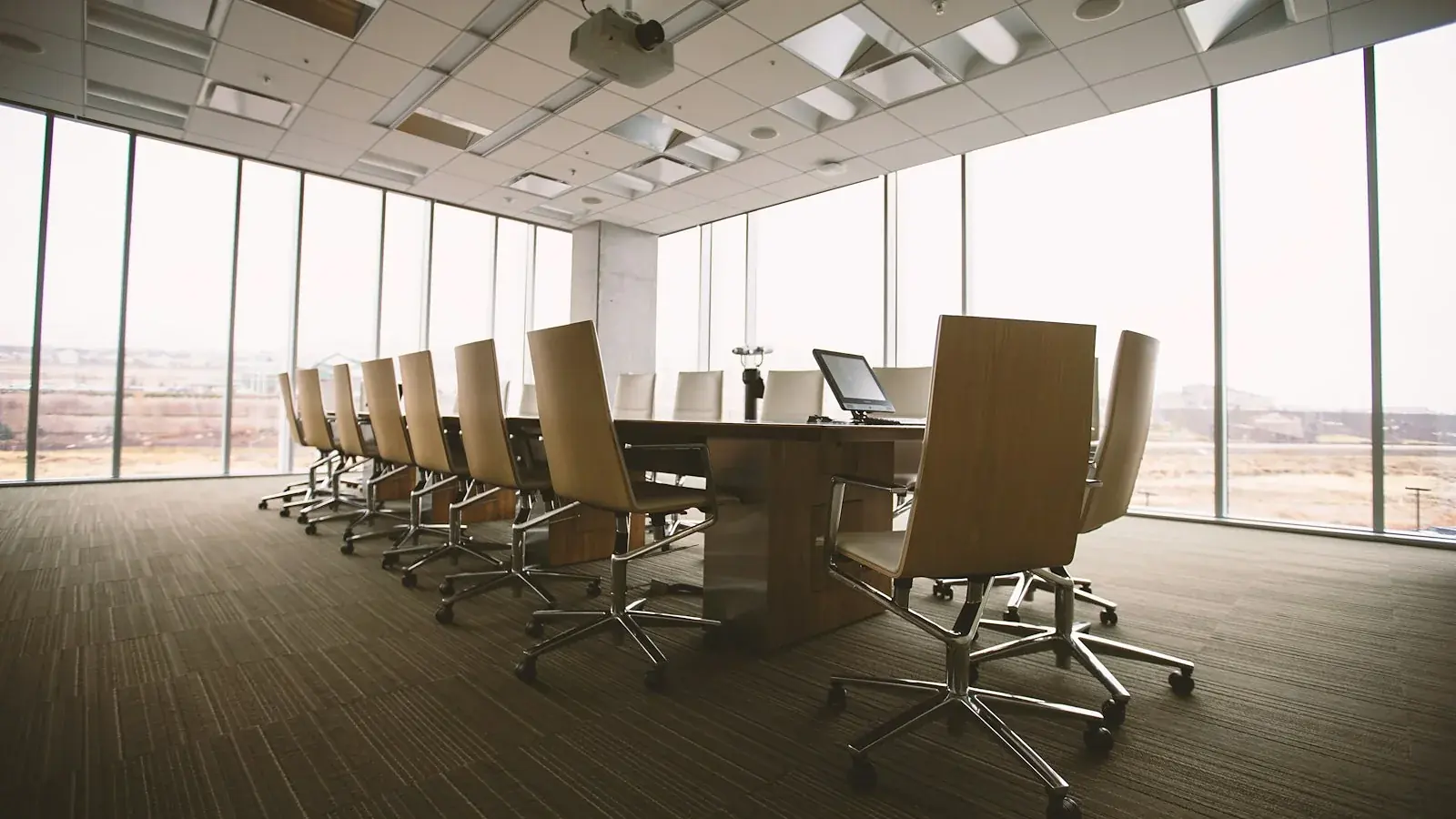 An empty boardroom table with chairs